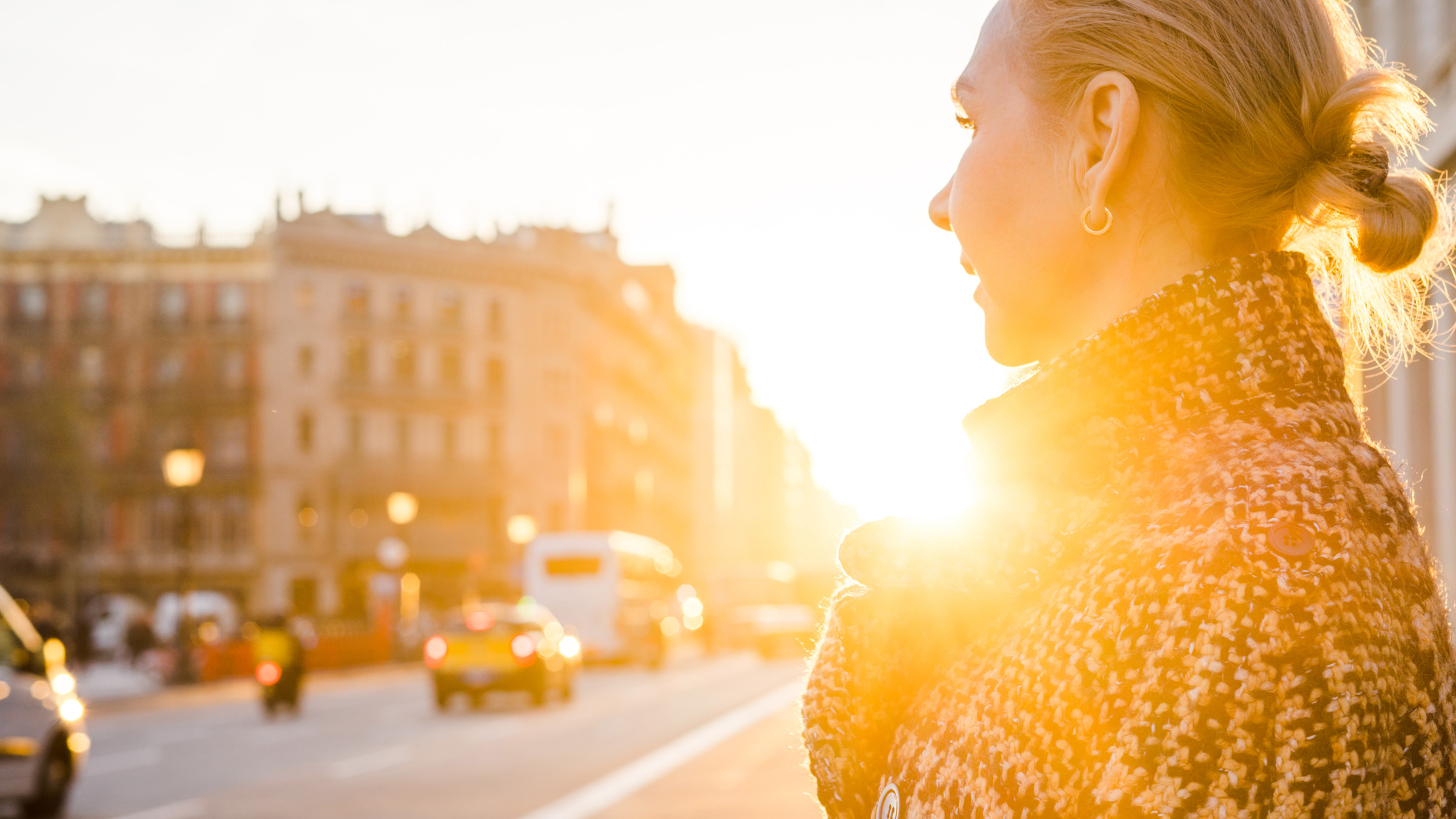Nainen kaupungissa auringonlaskun aikaan
