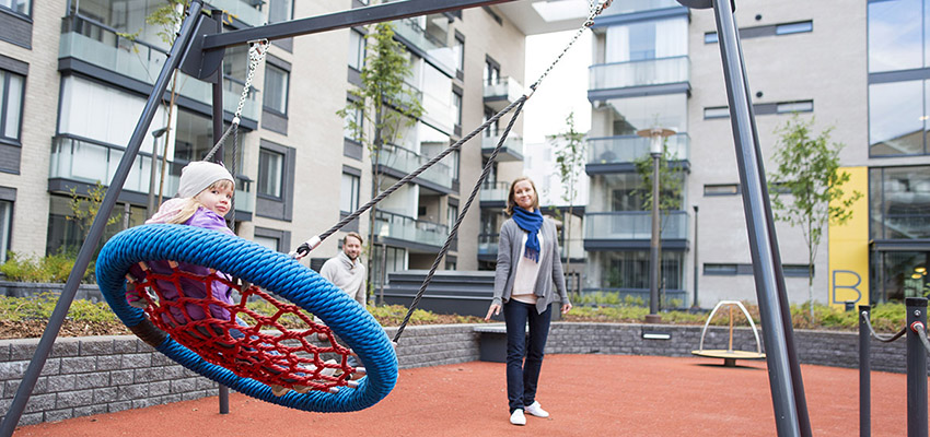 Lapsi keinuu viihtyisällä sisäpihalla