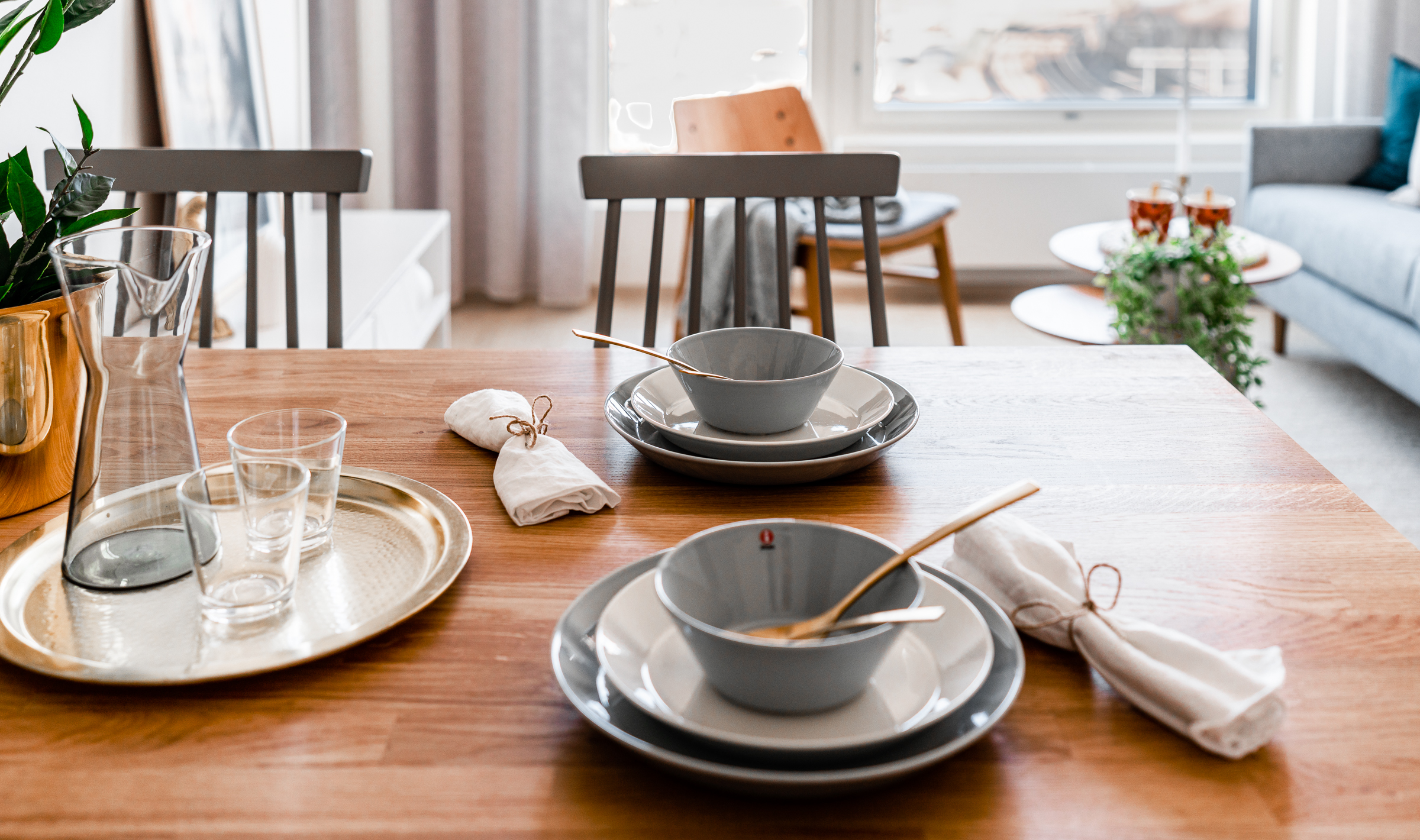 Tammen värinen ruokapöytä ja vaaleanharmaat pinnatuolit