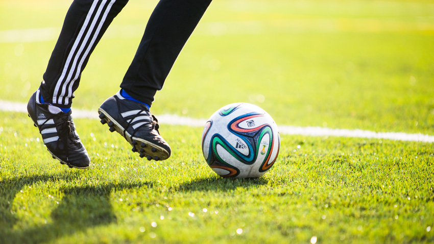 Soccer player and ball on the lawn