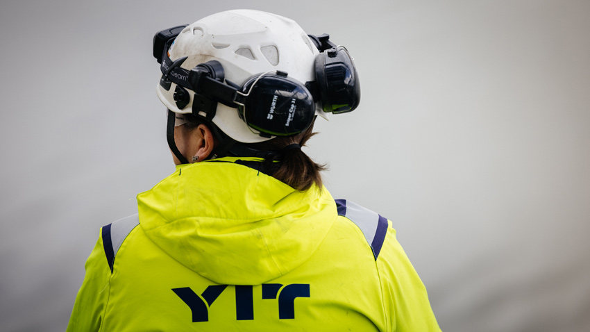 worksite worker with white helmet and jacket with YIT logo